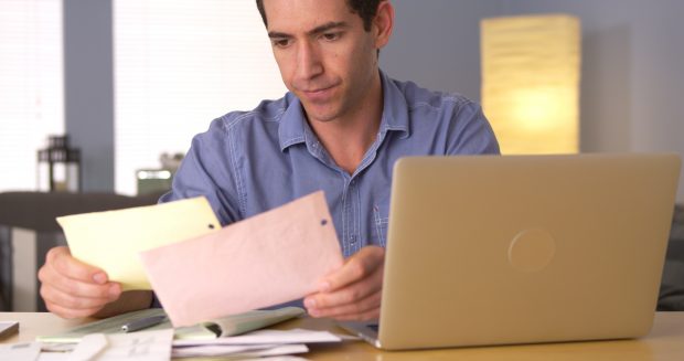 Image of a Man worries while looking through his bills - Represents schoolteacher concerned with bills before making million dollars