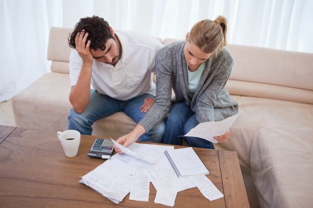 Image of a couple worried going through their bills - Represents that you should learn the truth about budget and never worry about being able to pay your bills anymore