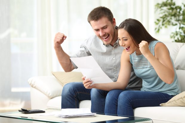 Image of a couple celebrating at home - represents that you should learn the truth about budget and start enjoying life as it should be